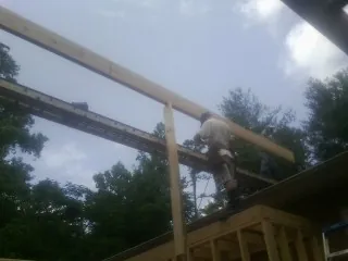 Carpenter setting a ridge beam over a new addition frame — Ice Dam Removal by Roofing Brothers in Grand Forks Afb
