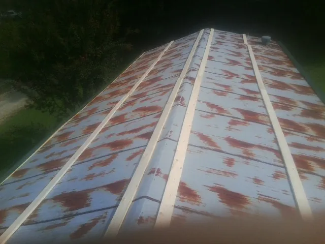 Rusted metal roof panels with new wood purlins before replacement — Storm Damage Roof Repair in Grand Forks Afb by Roofing Brothers