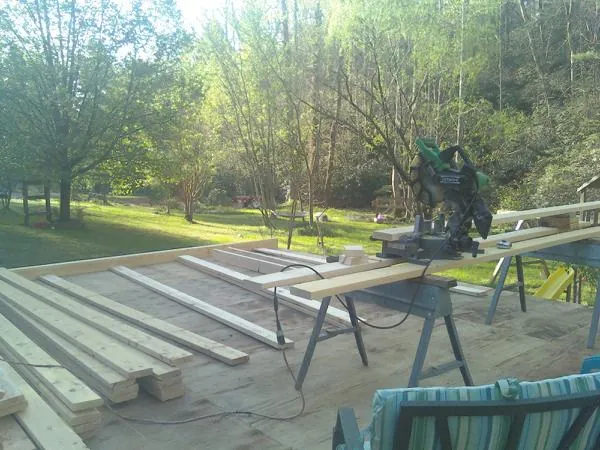 Miter saw and framing lumber on a deck under construction in Grand Forks Afb