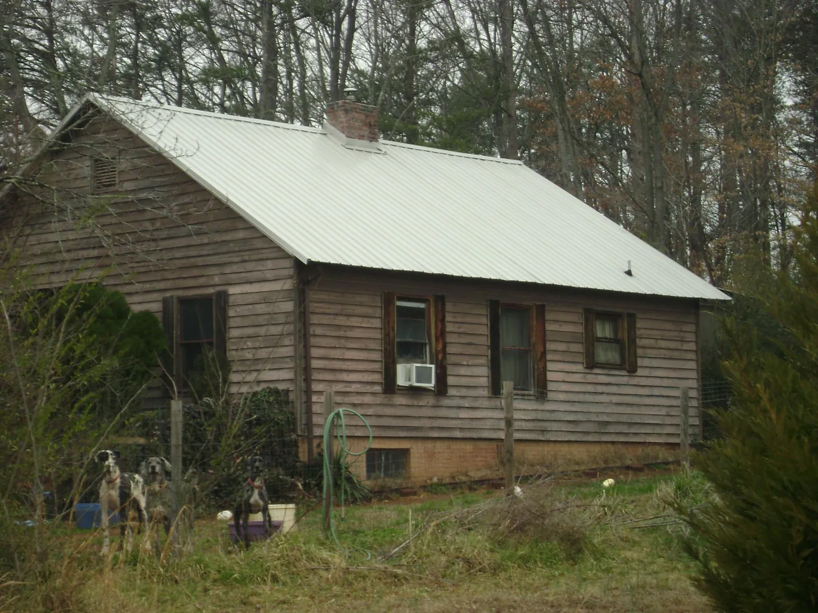 White metal roof on an old wood sided farmhouse, from a Asphalt Shingle Roof Repair job in Grand Forks Afb